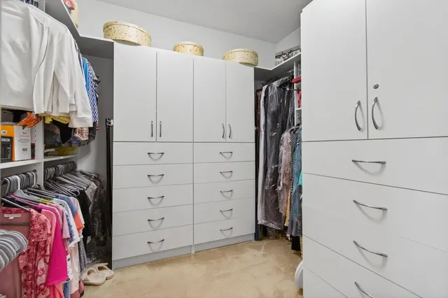 a view of walk in closet with clothes