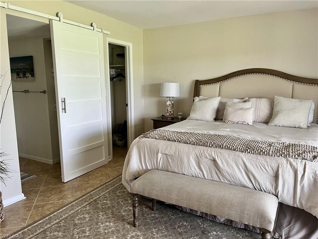 348 Tern Drive, Unit 4 Naples, FL 34112 - Photo 8 of 27 a bedroom with a bed and a mirror