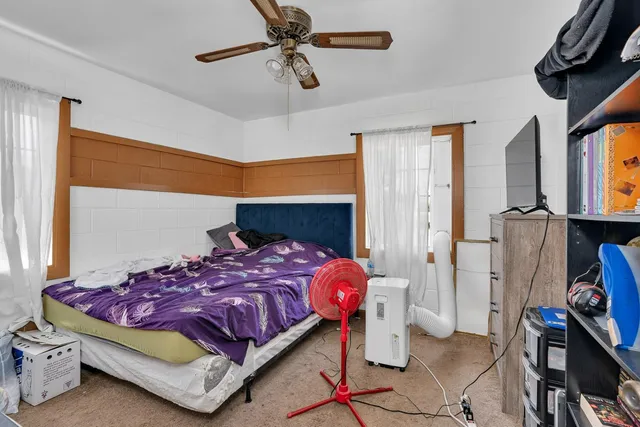 a bedroom with a bed a window and book shelf