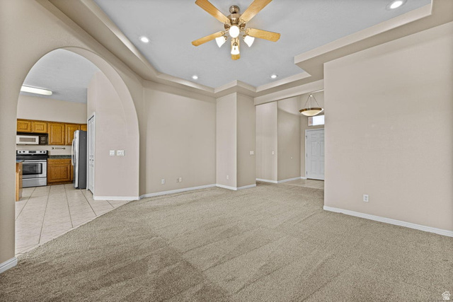 2226 East 140 South St. George, UT 84790 - Photo 5 of 20 Spacious living area featuring tray ceilings with recessed lighting, a ceiling fan, and carpet flooring