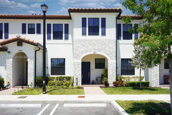 a front view of a house with yard and green space