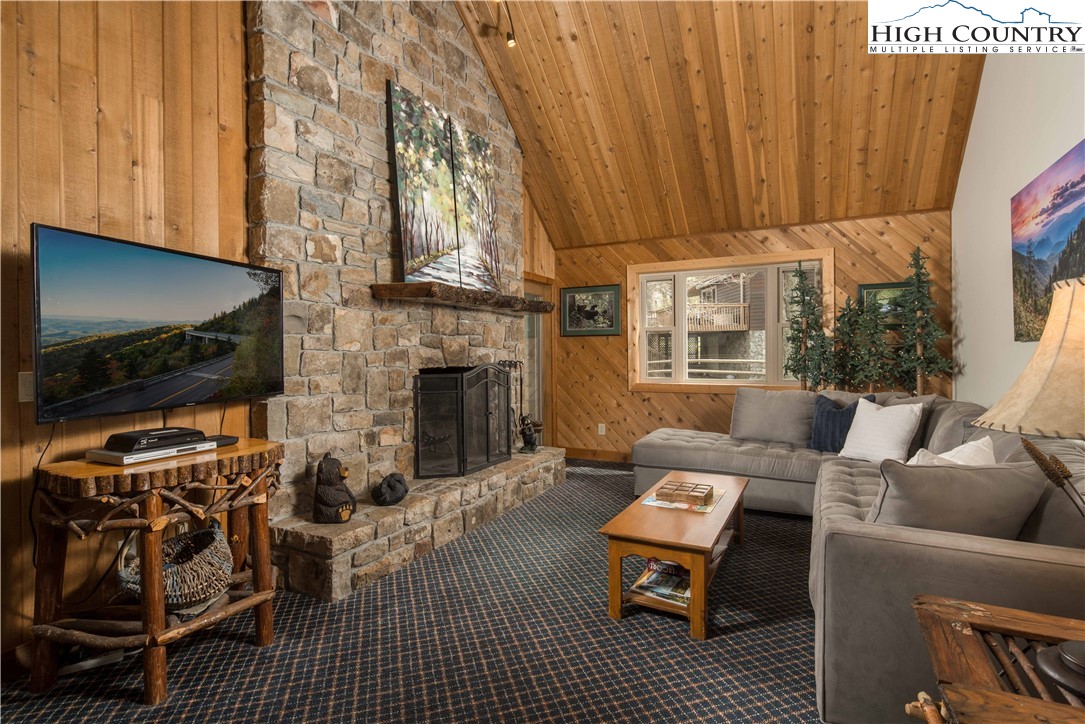 109 Old Field Road Beech Mountain, NC 28604 - Photo 15 of 50 a living room with furniture a flat screen tv and a fireplace