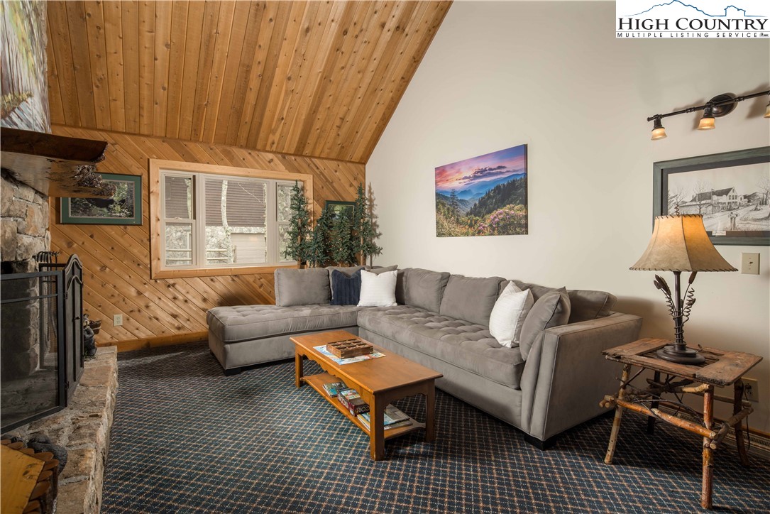 109 Old Field Road Beech Mountain, NC 28604 - Photo 16 of 50 a living room with furniture a rug and a fireplace
