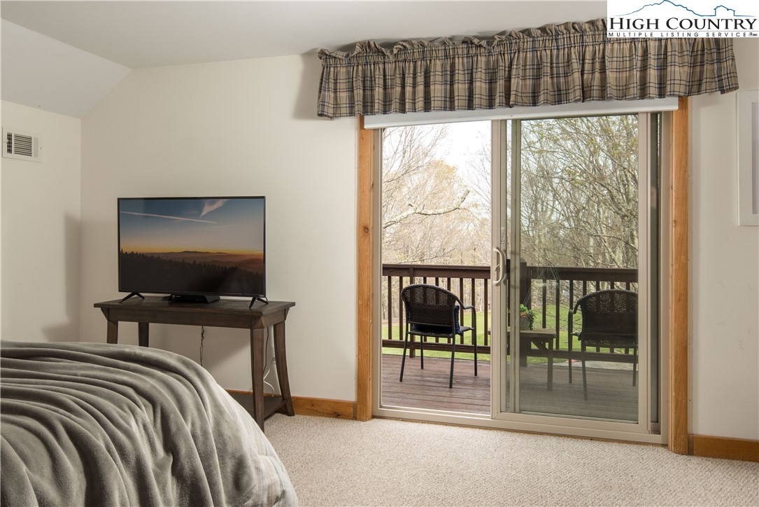 109 Old Field Road Beech Mountain, NC 28604 - Photo 29 of 50 a bedroom with a bed and a flat tv screen next to a window