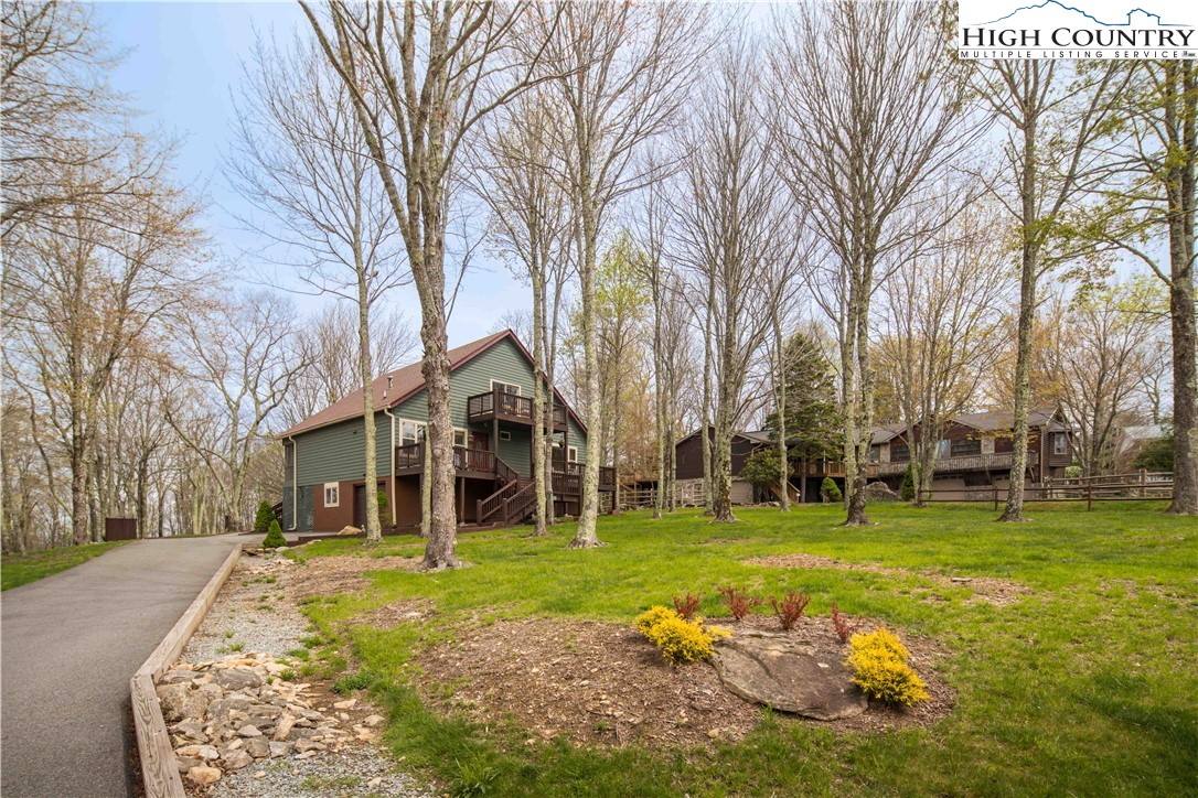 109 Old Field Road Beech Mountain, NC 28604 - Photo 6 of 50 a view of a house with a big yard and large trees