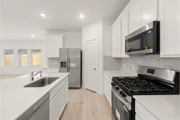 a kitchen with stainless steel appliances granite countertop a sink stove and refrigerator