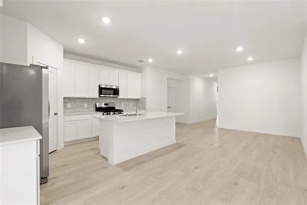a kitchen with white cabinets and stainless steel appliances