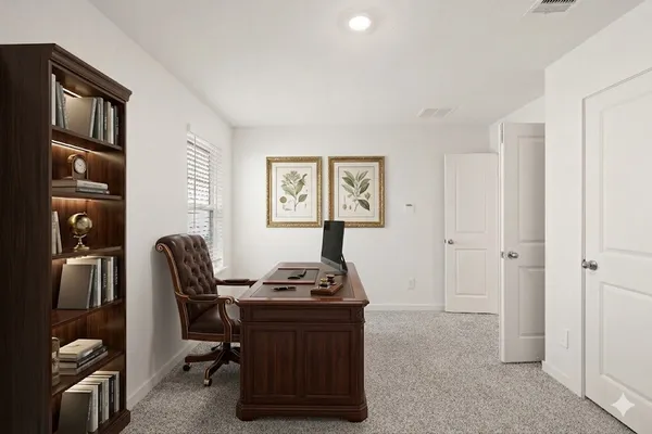 a view of a workspace with furniture and a window
