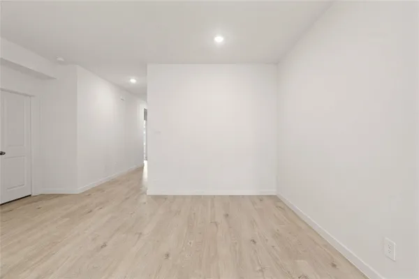an empty room with wooden floor and white walls