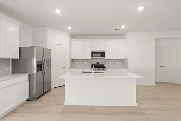a view of a kitchen with a sink stove and refrigerator