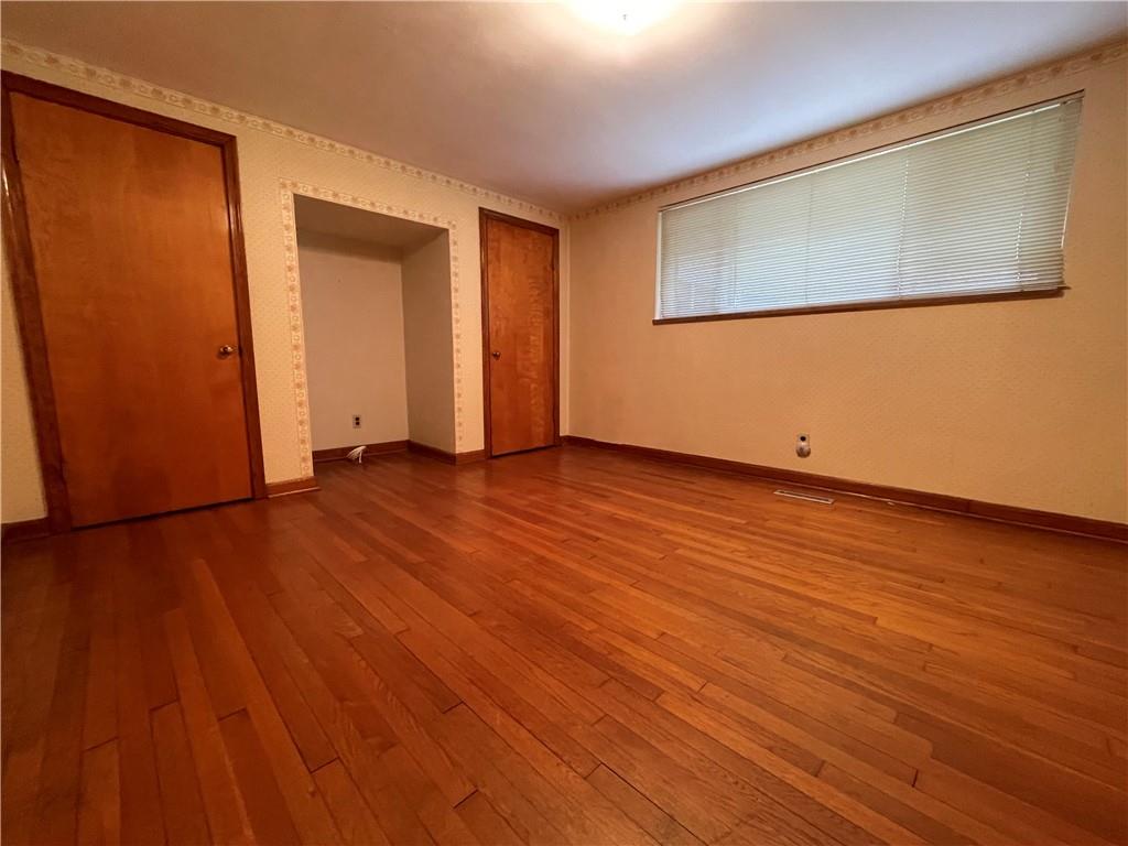2774 Pulaski Road New Castle, PA 16105 - Photo 13 of 19 a view of an empty room with wooden floor and a window