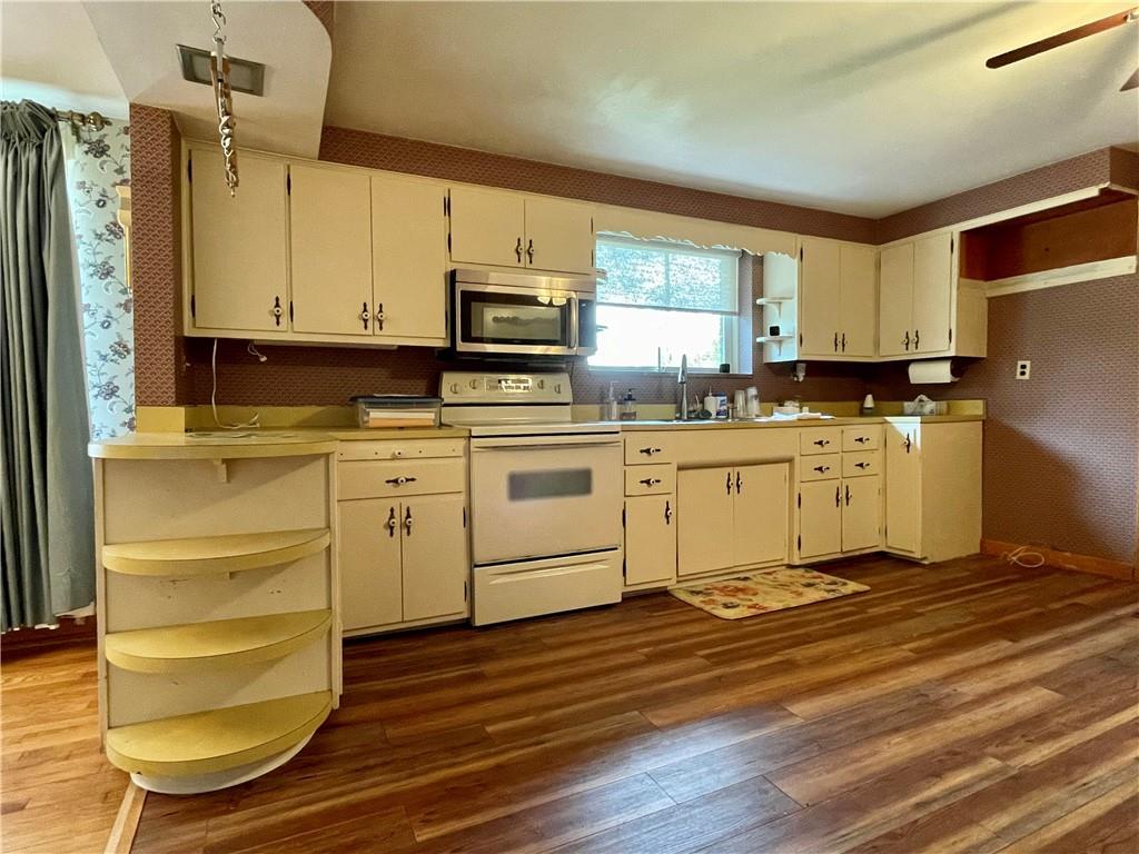 2774 Pulaski Road New Castle, PA 16105 - Photo 4 of 19 a kitchen with stainless steel appliances a stove a sink and white cabinets with wooden floor
