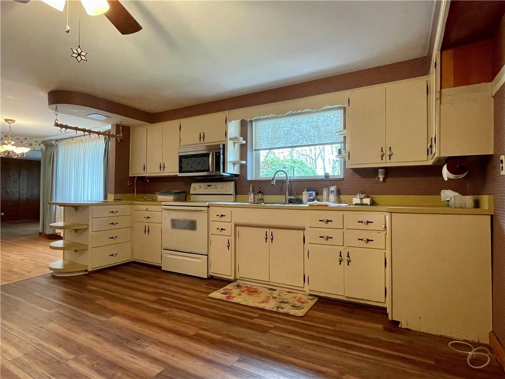 2774 Pulaski Road New Castle, PA 16105 - Photo 6 of 19 a kitchen with granite countertop a stove a sink dishwasher and a refrigerator with wooden floor