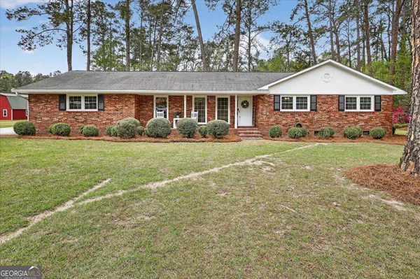 a front view of a house with a yard and trees