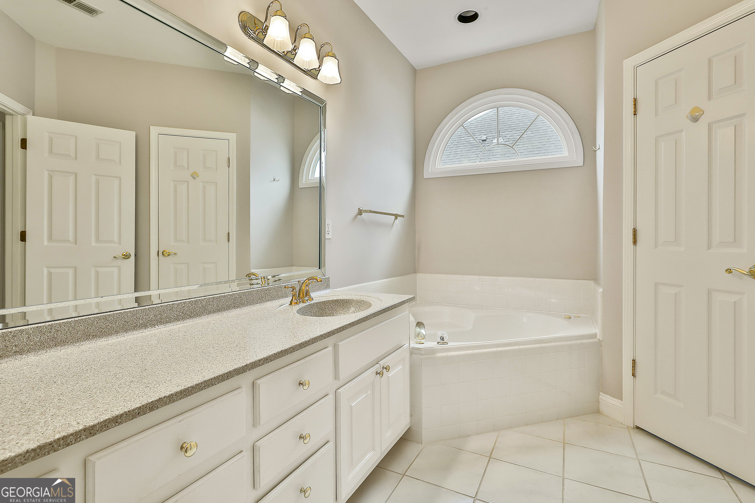 207 Prestwick Way North Stockbridge, GA 30281 - Photo 29 of 44 a bathroom with a sink a vanity a mirror and a bathtub