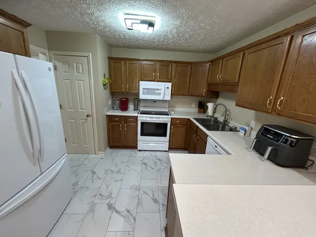 a kitchen with stainless steel appliances a refrigerator a sink a stove top oven and a refrigerator