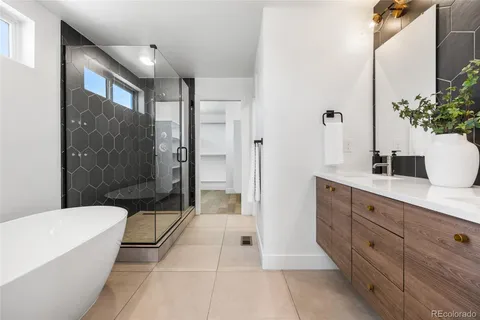 a spacious bathroom with a tub shower sink and mirror