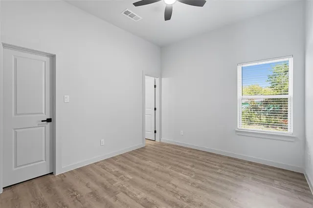 an empty room with fan and windows