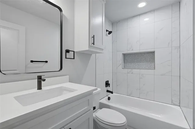 a bathroom with a bathtub shower sink and toilet