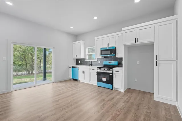 a kitchen with a refrigerator a stove top oven and a sink