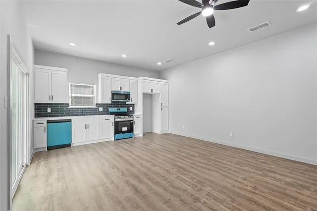 a kitchen with stainless steel appliances granite countertop a stove a sink and a refrigerator