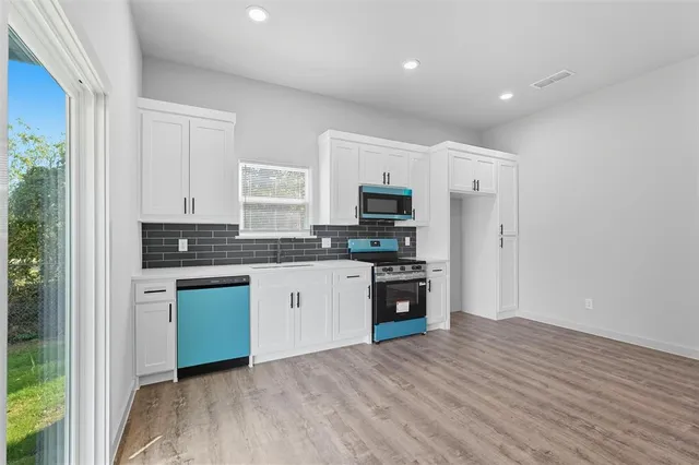 a kitchen with granite countertop a refrigerator stove top oven and sink