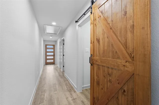 a view of a hallway with wooden floor and entryway