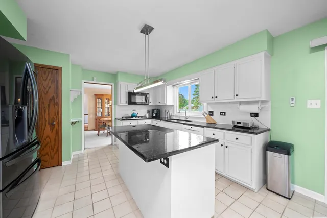 a kitchen with granite countertop a sink stainless steel appliances and cabinets