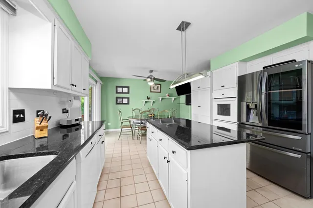 a kitchen with stainless steel appliances granite countertop a sink and a refrigerator