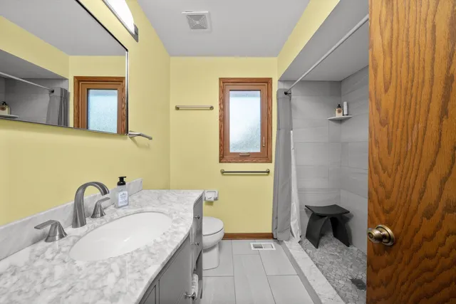 a bathroom with a granite countertop sink and a mirror