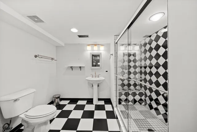 a bathroom with a black and white checkered floor