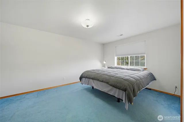 a spacious bedroom with a bed and a window