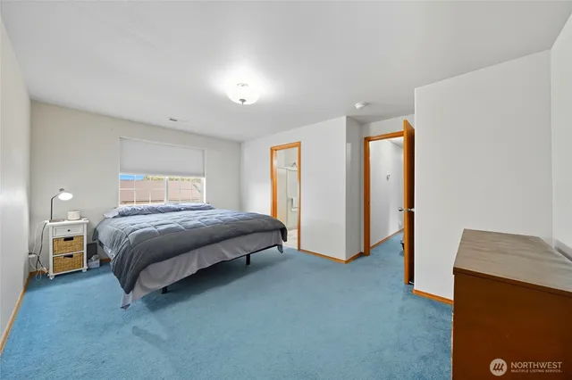 a spacious bedroom with a bed and a lamp