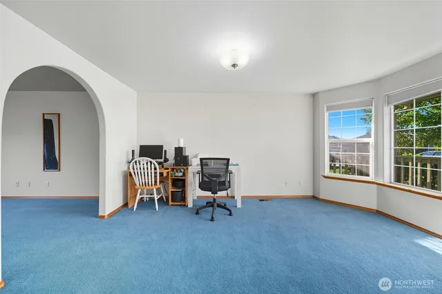 a view of a workspace with furniture and a window