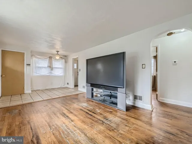 a view of a livingroom with wooden floor and a flat screen tv