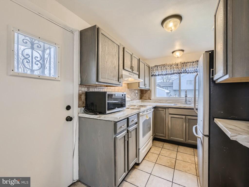 4816 Valley Forge Road Randallstown, MD 21133 - Photo 7 of 11 a kitchen with stainless steel appliances granite countertop a stove a sink and a refrigerator