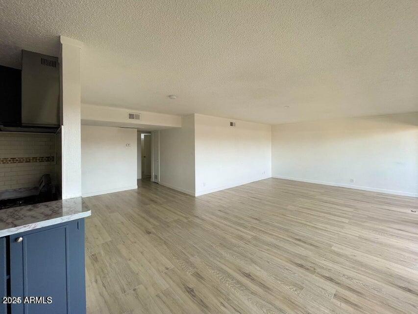 6767 North 7th Street, Unit 227 Phoenix, AZ 85014 - Photo 2 of 11 a view of an empty room with wooden floor and a flat screen tv