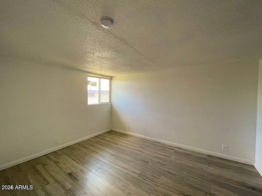 6767 North 7th Street, Unit 227 Phoenix, AZ 85014 - Photo 3 of 11 an empty room with wooden floor and windows