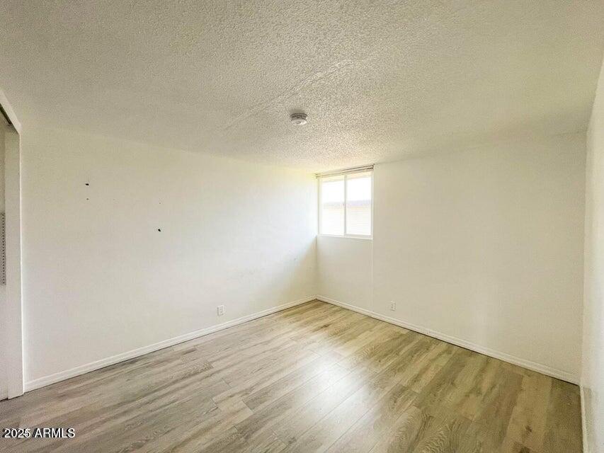 6767 North 7th Street, Unit 227 Phoenix, AZ 85014 - Photo 4 of 11 an empty room with wooden floor and windows