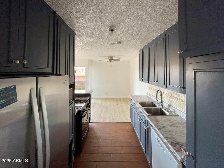 6767 North 7th Street, Unit 227 Phoenix, AZ 85014 - Photo 7 of 11 a kitchen with stainless steel appliances granite countertop a refrigerator and a sink