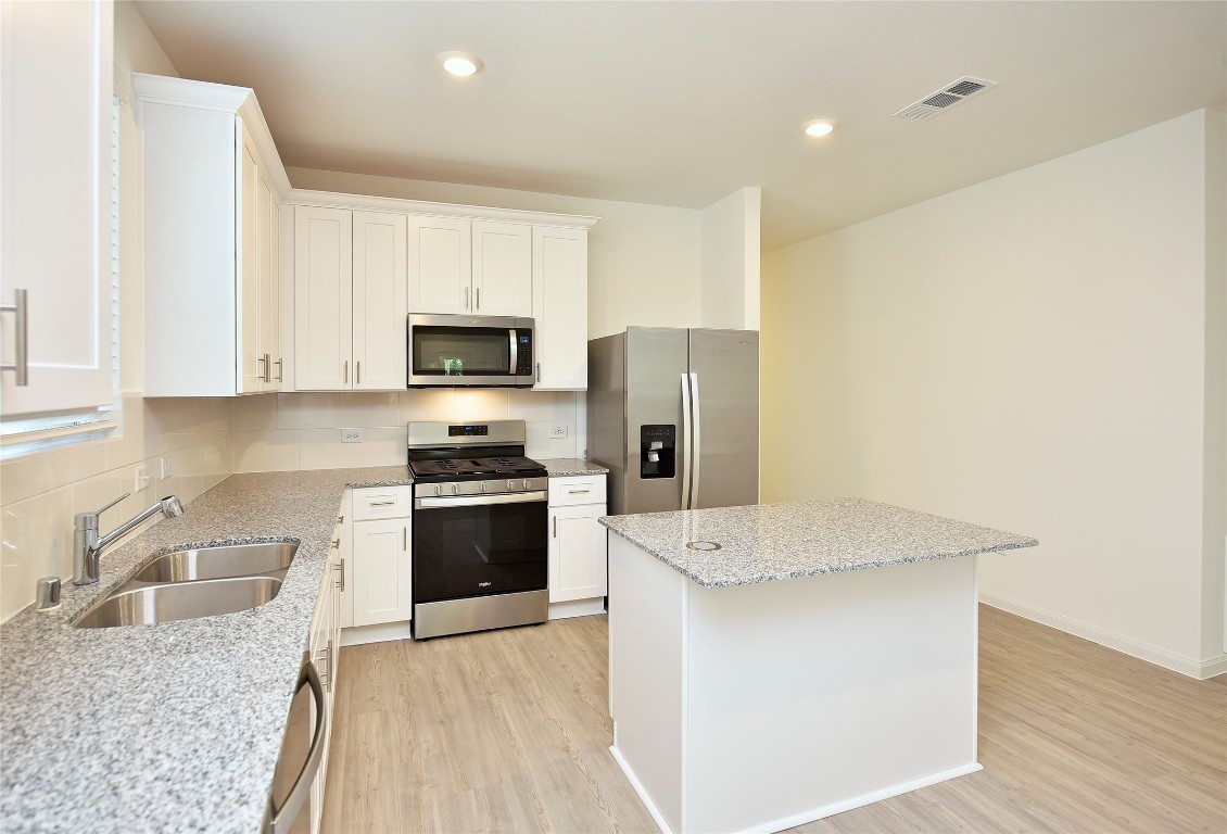 25473 Cilantro Drive Magnolia, TX 77355 - Photo 9 of 21 a kitchen with granite countertop cabinets stainless steel appliances and a counter space