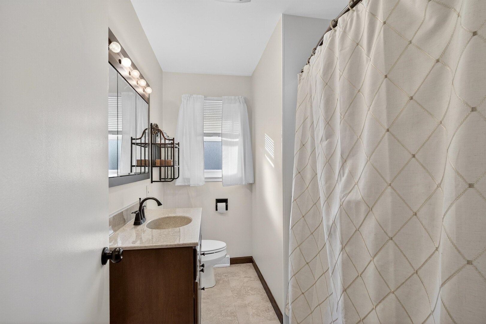1136 4th Avenue North Clinton, IA 52732 - Photo 14 of 34 a bathroom with a sink and mirror with bathtub