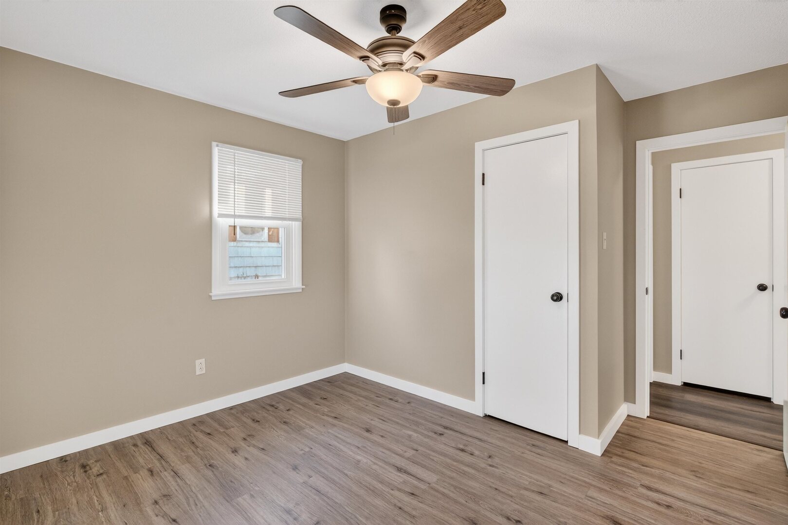 1136 4th Avenue North Clinton, IA 52732 - Photo 20 of 34 an empty room with wooden floor chandelier fan and windows