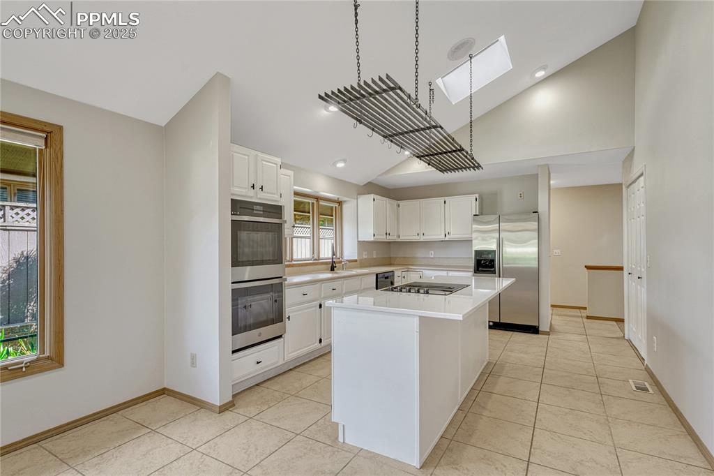 3120 Camels Ridge Lane Colorado Springs, CO 80904 - Photo 12 of 50 Vaulted Tiled Island Kitchen, Skylight