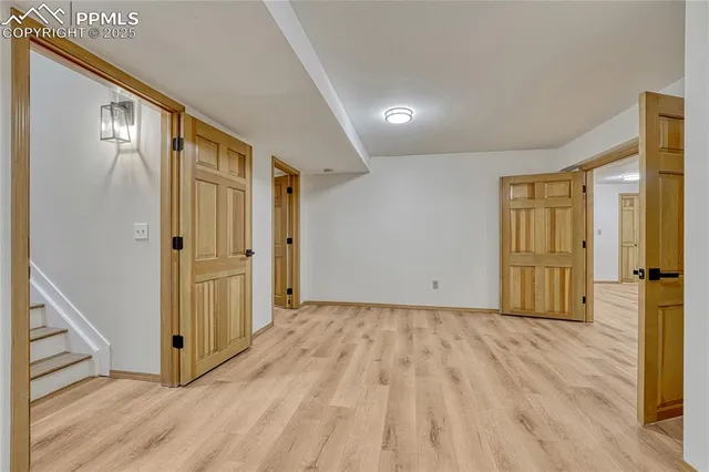 a view of a hallway with wooden floor and entryway