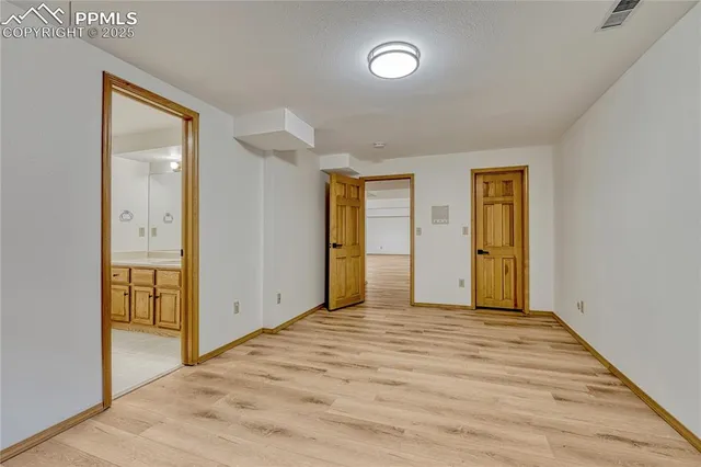 a view of an empty room with window and bathroom