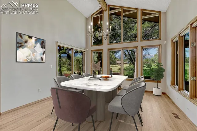 a view of a dining room with furniture large windows and wooden floor