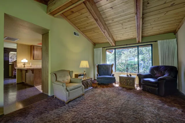 a living room with furniture a flat screen tv and large windows