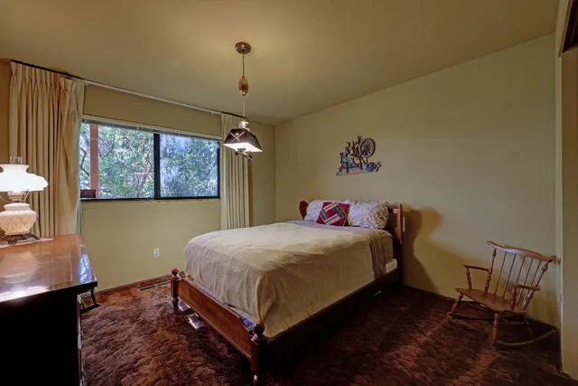 a bedroom with a bed a window and dresser