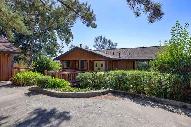 a front view of a house with a yard and potted plants